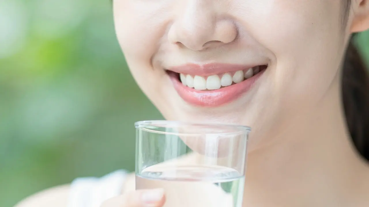 Detail zdravého úsměvu s abstraktním motivem zelené zahrady symbolizující rovnováhu.